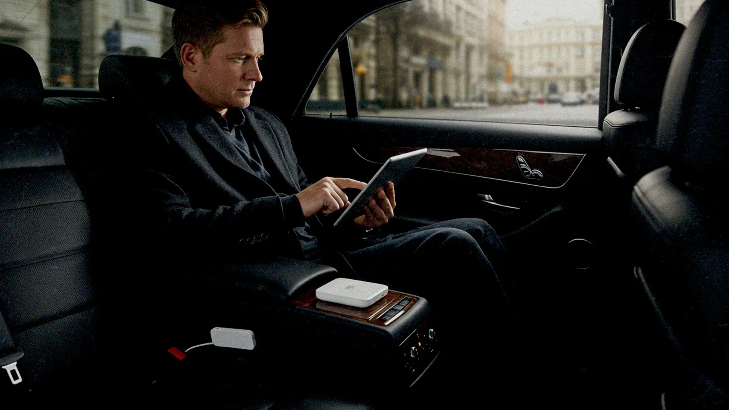 ハイヤーの車内でタブレットを操作する男性