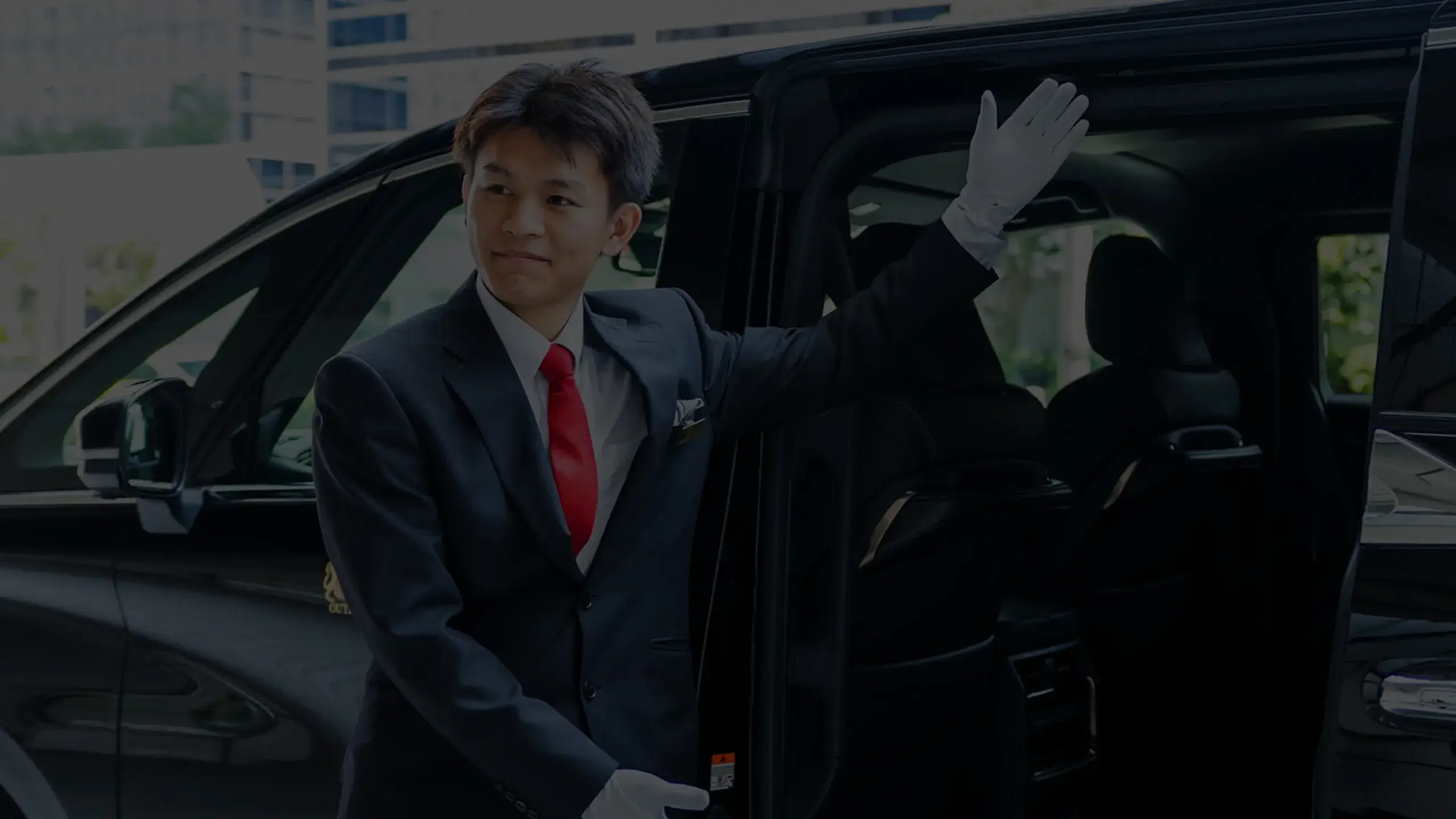 ハイヤーのドアを開けるアウトドアプランナー