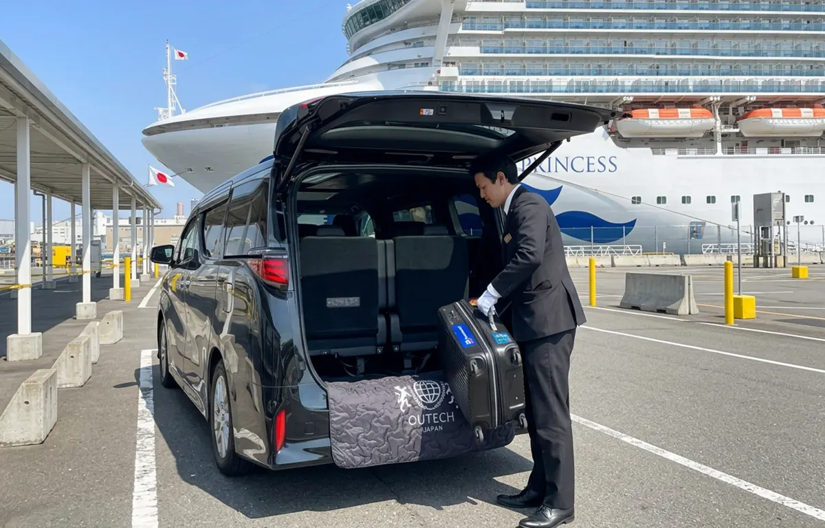 Chauffeur loading luggage into a Toyota Alphard