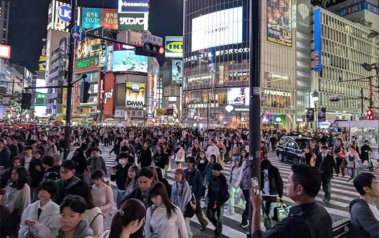 活気あふれる夜の渋谷スクランブル交差点を渡る大勢の人々
