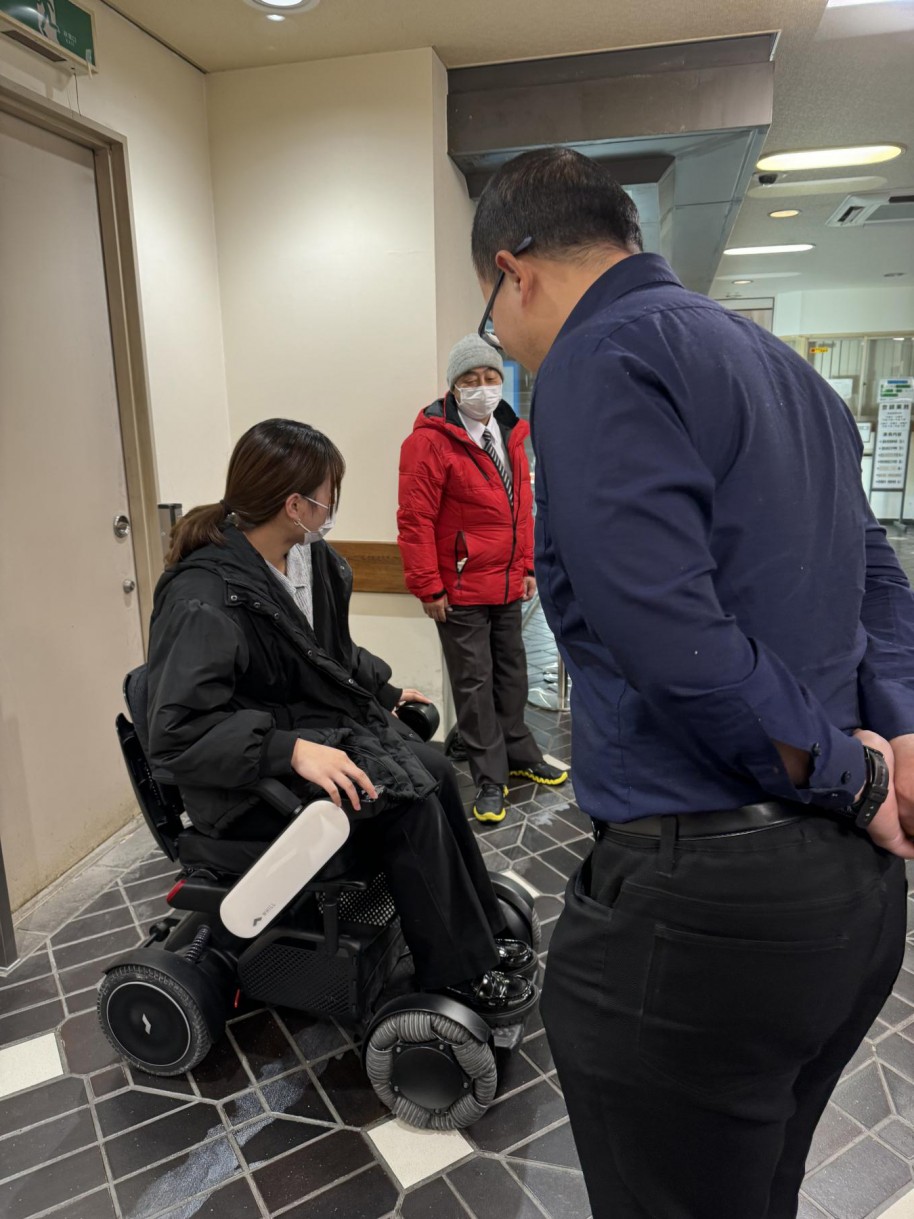 電動車椅子を体験する串田さんと見守る胡さん